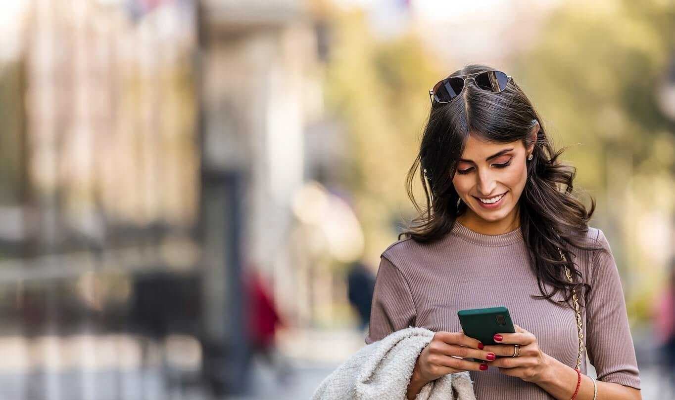 Woman looking at smartphone walking